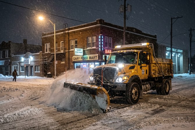Snow removal truck with plow blade working through heavy snow